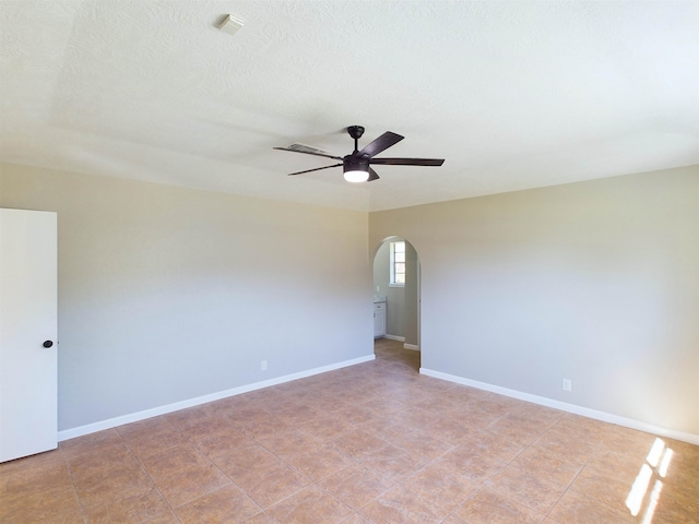 tiled empty room featuring ceiling fan and a textured ceiling