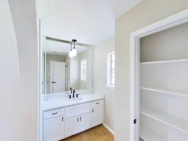 bathroom featuring a textured ceiling, vanity, and tile patterned floors