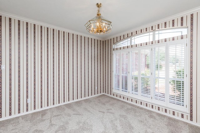 carpeted empty room with an inviting chandelier and crown molding