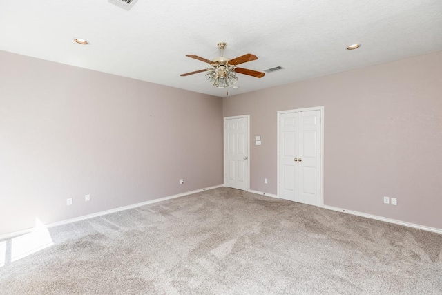 carpeted spare room with ceiling fan and a textured ceiling