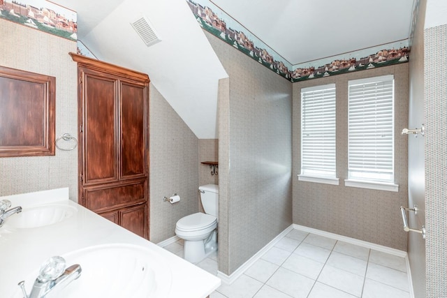 bathroom with tile patterned floors, vanity, toilet, and lofted ceiling