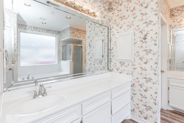 bathroom with plus walk in shower, wood-type flooring, and vanity