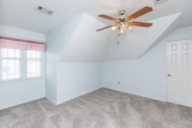 additional living space with ceiling fan, light colored carpet, and lofted ceiling