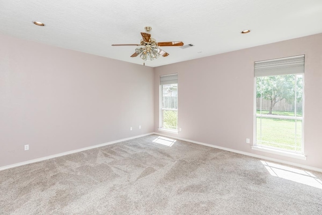 unfurnished room with ceiling fan, carpet floors, and a textured ceiling