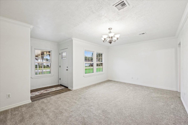 entryway with carpet flooring, an inviting chandelier, visible vents, and crown molding
