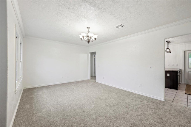 unfurnished bedroom with baseboards, ornamental molding, visible vents, a chandelier, and light carpet
