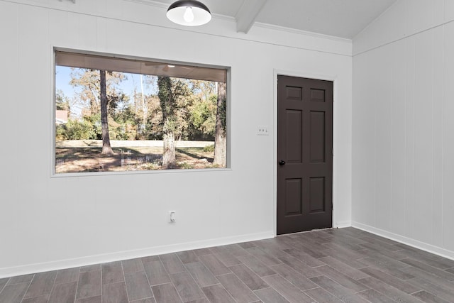 spare room featuring beam ceiling, hardwood / wood-style flooring, and ornamental molding