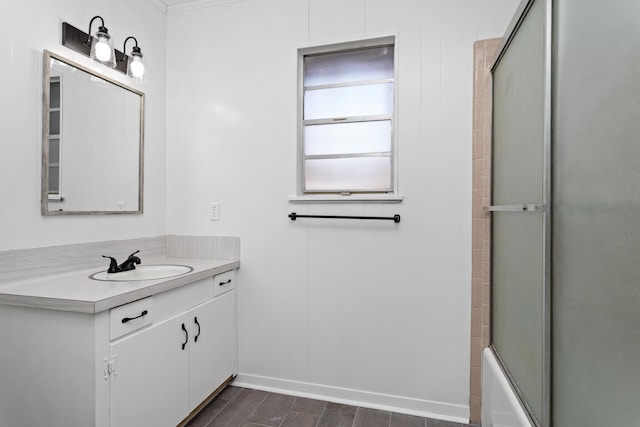 bathroom with vanity, ornamental molding, and bath / shower combo with glass door