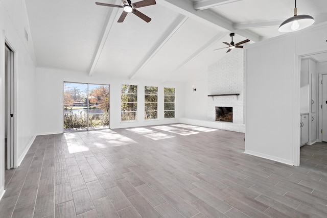 unfurnished living room with ceiling fan, a fireplace, and lofted ceiling with beams