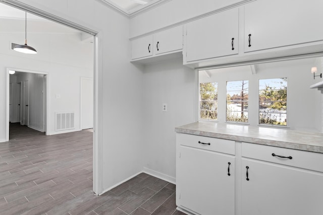 kitchen with white cabinets, decorative light fixtures, and ornamental molding