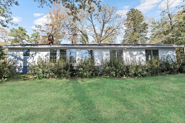 rear view of house featuring a lawn