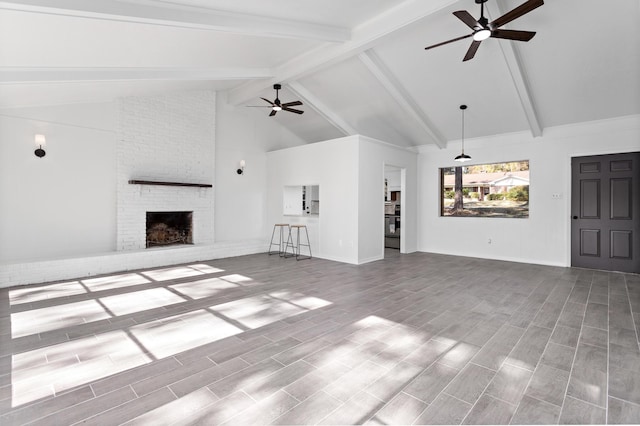 unfurnished living room featuring a brick fireplace, high vaulted ceiling, ceiling fan, and beam ceiling