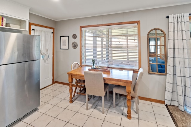 dining area with crown molding and light tile patterned flooring