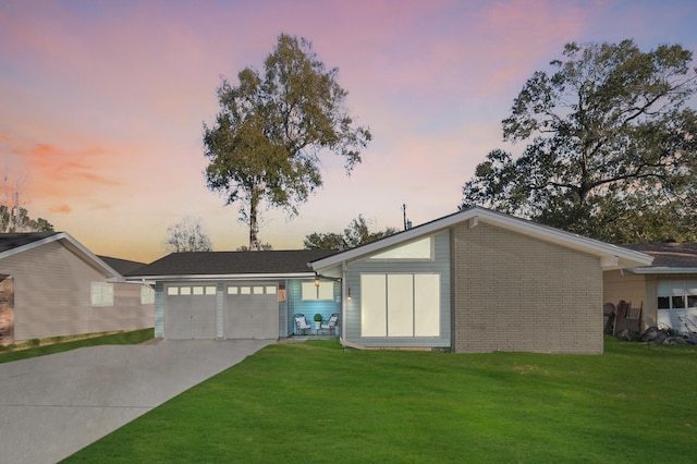 single story home featuring a lawn and a garage