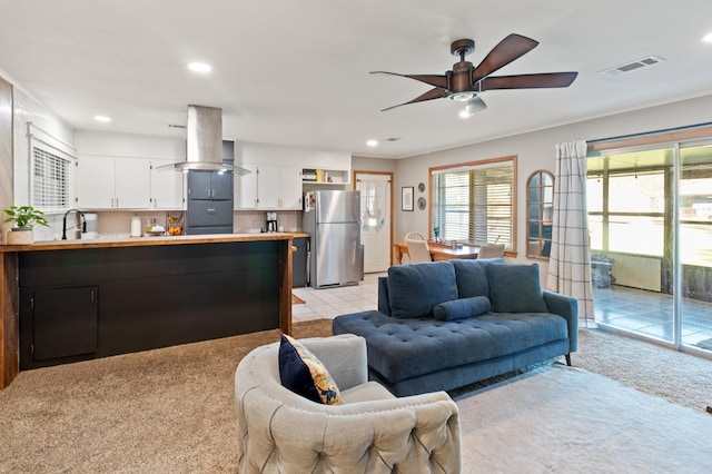 living room with ceiling fan and light colored carpet