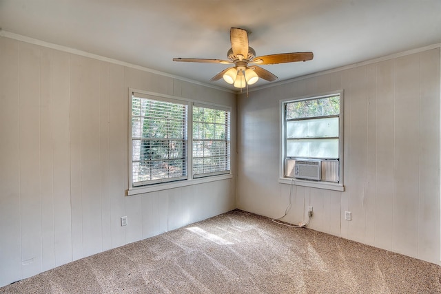 carpeted spare room with crown molding, a ceiling fan, cooling unit, and a healthy amount of sunlight
