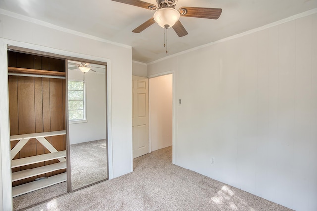 unfurnished bedroom featuring crown molding, a closet, ceiling fan, and carpet