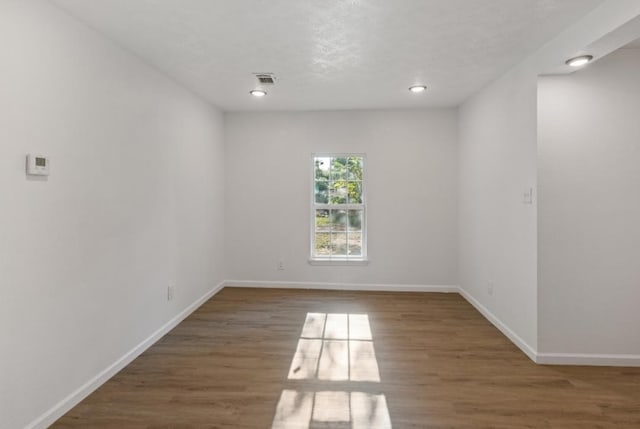 unfurnished room with baseboards, recessed lighting, and wood finished floors