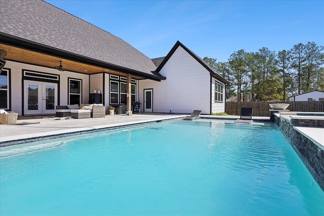 view of swimming pool featuring a patio, outdoor lounge area, fence, a ceiling fan, and french doors