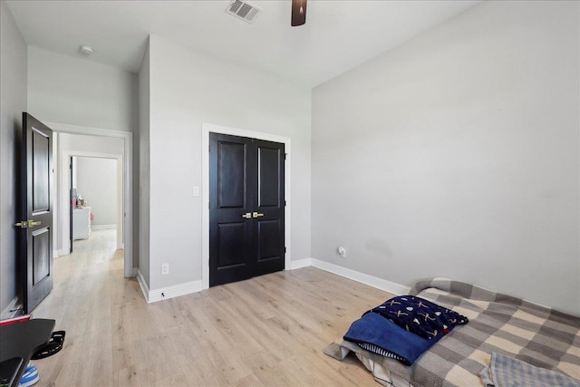 bedroom featuring a ceiling fan, light wood-type flooring, visible vents, and baseboards