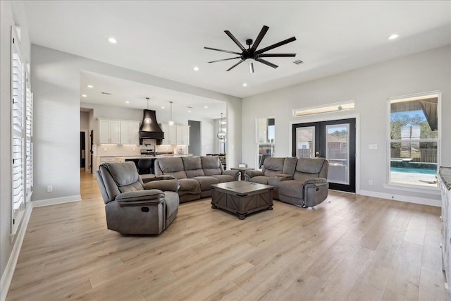 living area featuring light wood-style floors, recessed lighting, baseboards, and french doors