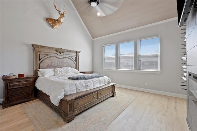 bedroom with lofted ceiling, light wood-style floors, baseboards, and ornamental molding