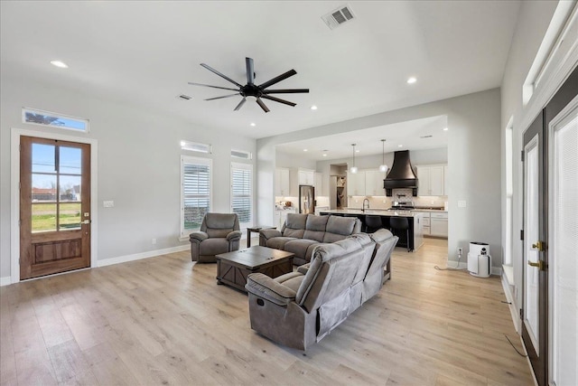 living room featuring recessed lighting, visible vents, light wood-style flooring, and baseboards