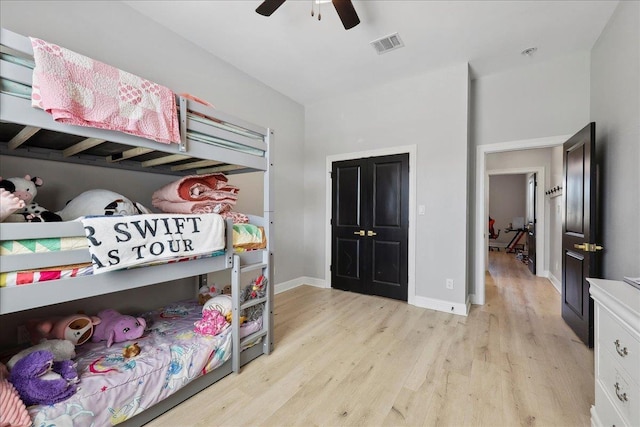 bedroom with baseboards, a ceiling fan, visible vents, and light wood-style floors