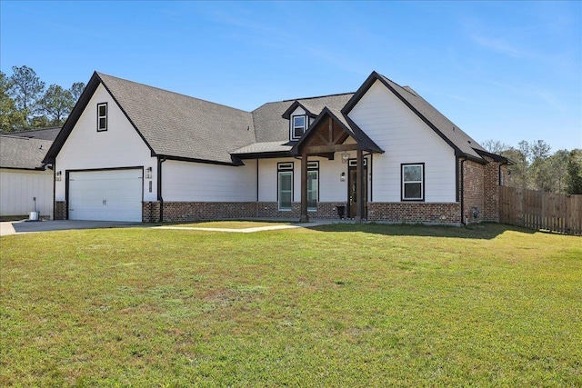 modern farmhouse with a front yard, brick siding, fence, and driveway