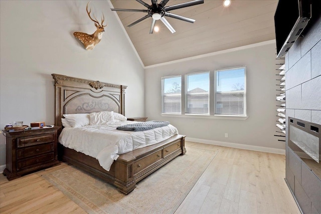 bedroom with lofted ceiling, crown molding, light wood-style flooring, and baseboards