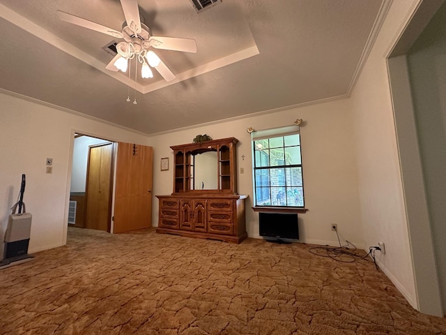 unfurnished bedroom featuring carpet flooring, ceiling fan, a raised ceiling, and crown molding