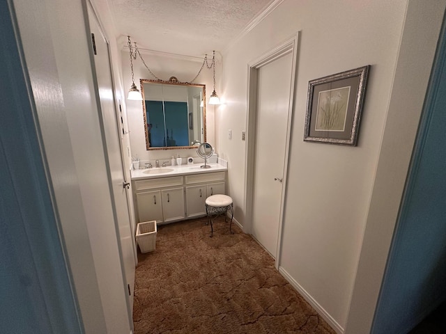 bathroom featuring vanity, ornamental molding, and a textured ceiling