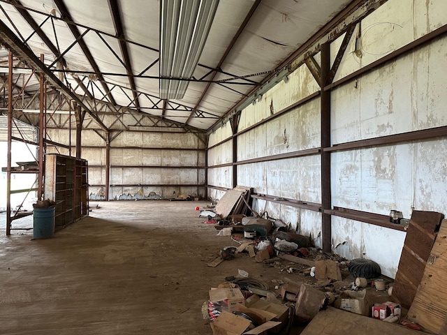 miscellaneous room with a towering ceiling and concrete flooring