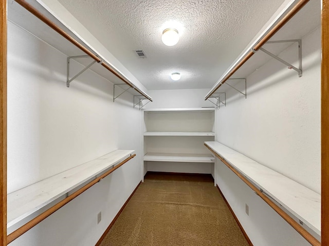 spacious closet featuring dark carpet