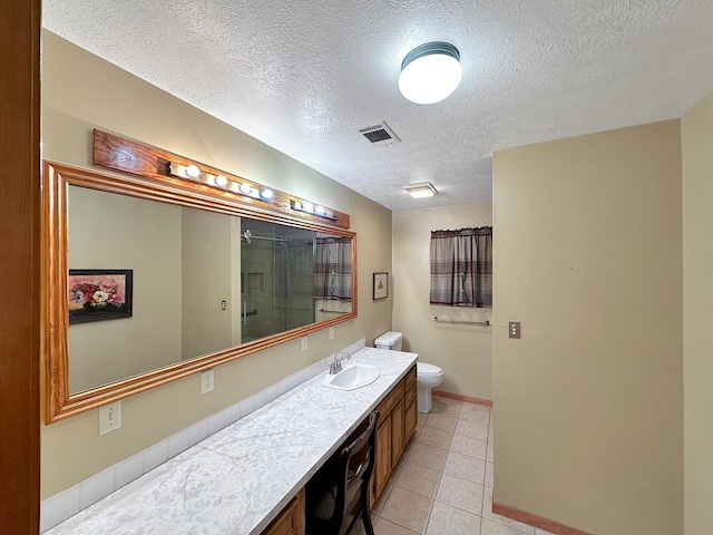 bathroom with tile patterned floors, an enclosed shower, a textured ceiling, toilet, and vanity