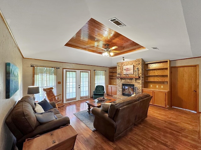 living room with french doors, light wood-type flooring, a brick fireplace, ceiling fan, and wooden ceiling