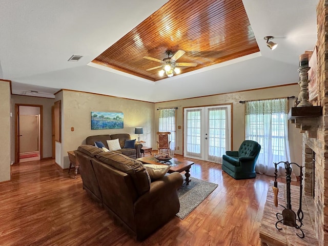 living room with a tray ceiling, french doors, hardwood / wood-style floors, and wood ceiling