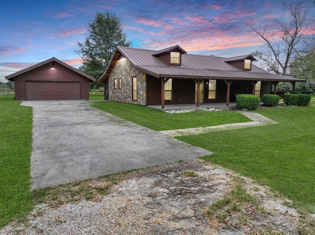 view of front of property with an outdoor structure, a lawn, a porch, and a garage