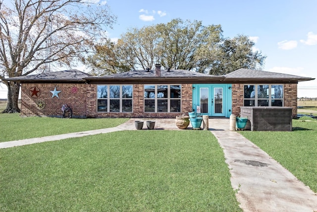 back of house featuring a yard and french doors