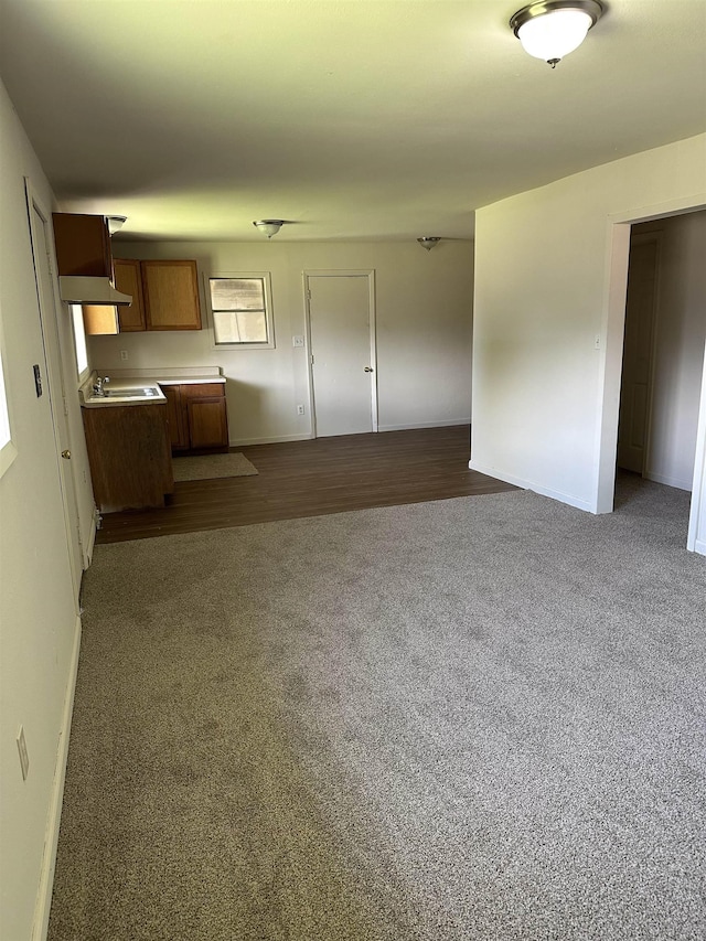2910 Dowling St, Orange, TX 77630 - unfurnished living room with a sink, baseboards, and dark colored carpet