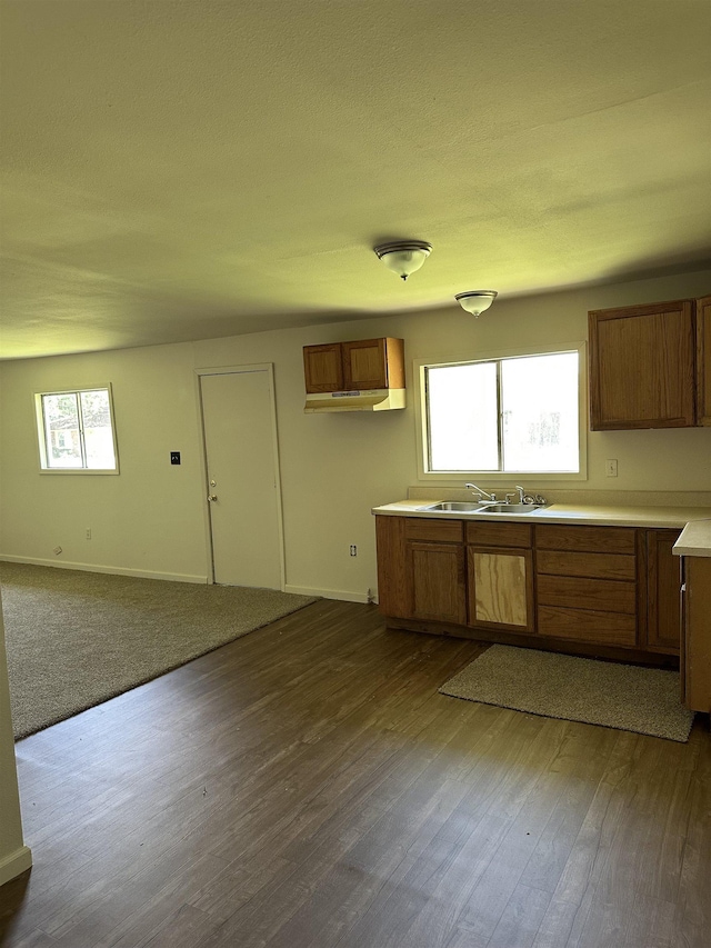 2910 Dowling St, Orange, TX 77630 - kitchen with brown cabinets, baseboards, light countertops, dark wood finished floors, and a sink