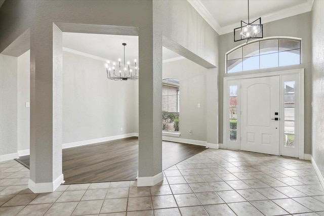 foyer featuring light tile patterned floors, crown molding, and a notable chandelier