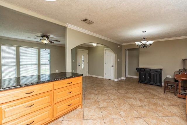 970 Charleston Cir, Bridge City, TX 77611 - kitchen featuring arched walkways, a ceiling fan, crown molding, a chandelier, and dark stone counters