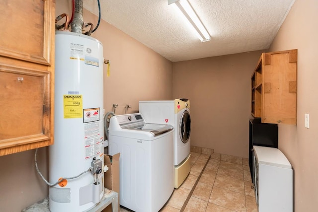 970 Charleston Cir, Bridge City, TX 77611 - laundry room featuring gas water heater, cabinet space, a textured ceiling, washing machine and clothes dryer, and light tile patterned floors