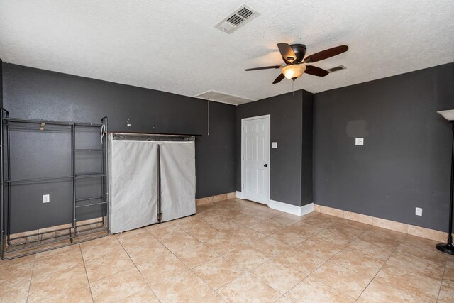 970 Charleston Cir, Bridge City, TX 77611 - spare room featuring ceiling fan, attic access, a textured ceiling, and light tile patterned flooring