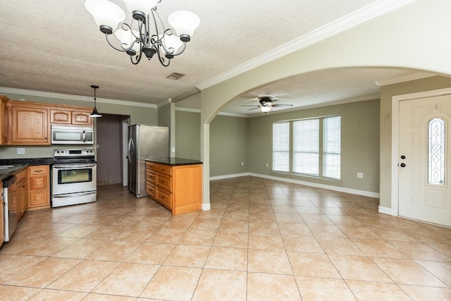 970 Charleston Cir, Bridge City, TX 77611 - kitchen featuring stainless steel appliances, arched walkways, dark countertops, light tile patterned floors, and a textured ceiling