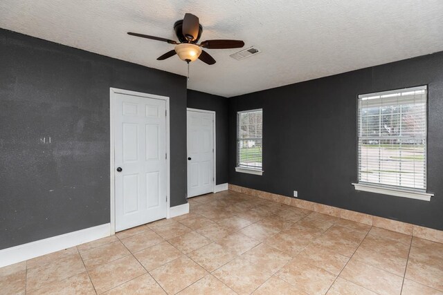 970 Charleston Cir, Bridge City, TX 77611 - spare room featuring a ceiling fan, a textured ceiling, and light tile patterned floors