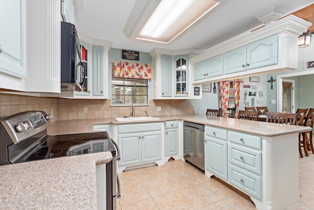 kitchen with kitchen peninsula, sink, white cabinets, and appliances with stainless steel finishes