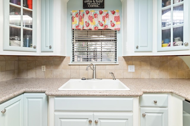 kitchen with tasteful backsplash, sink, and white cabinets