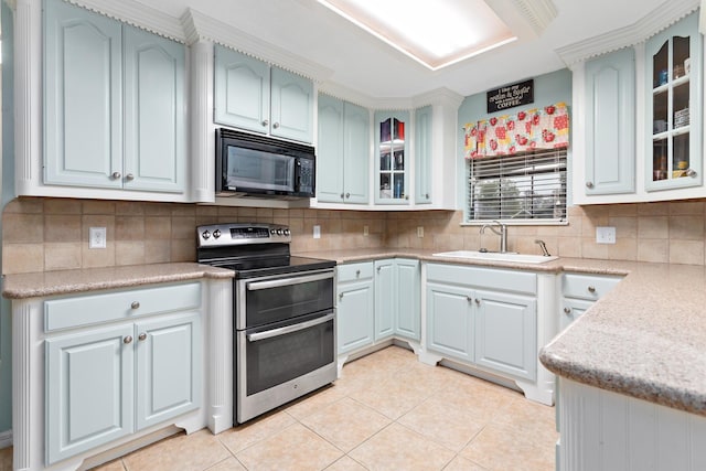 kitchen featuring electric range, backsplash, light tile patterned floors, and sink